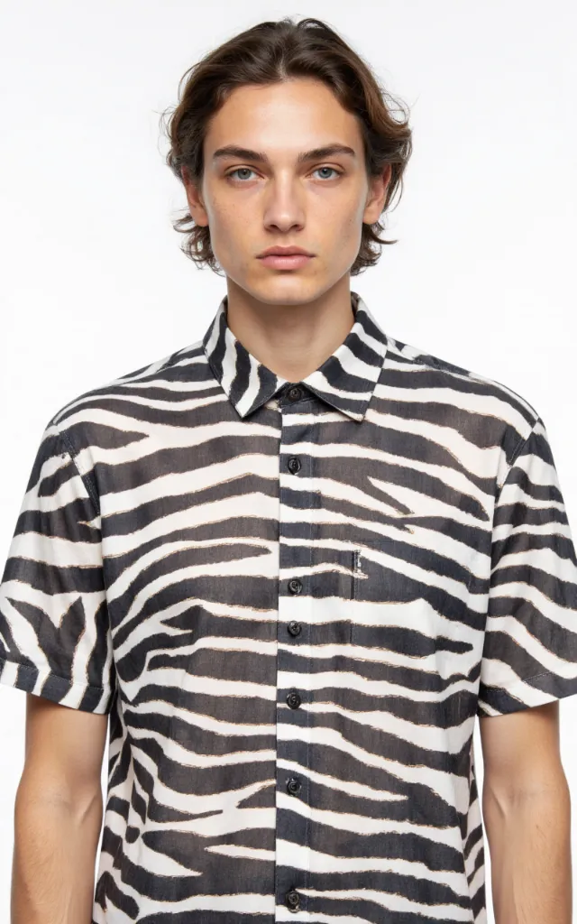 A French model wearing a Zebra print pattern   printed shirt, against a white background, in a front   facing bust portrait